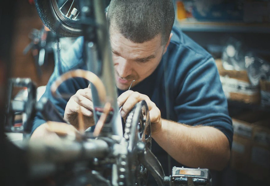 mężczyzna naprawiający rower